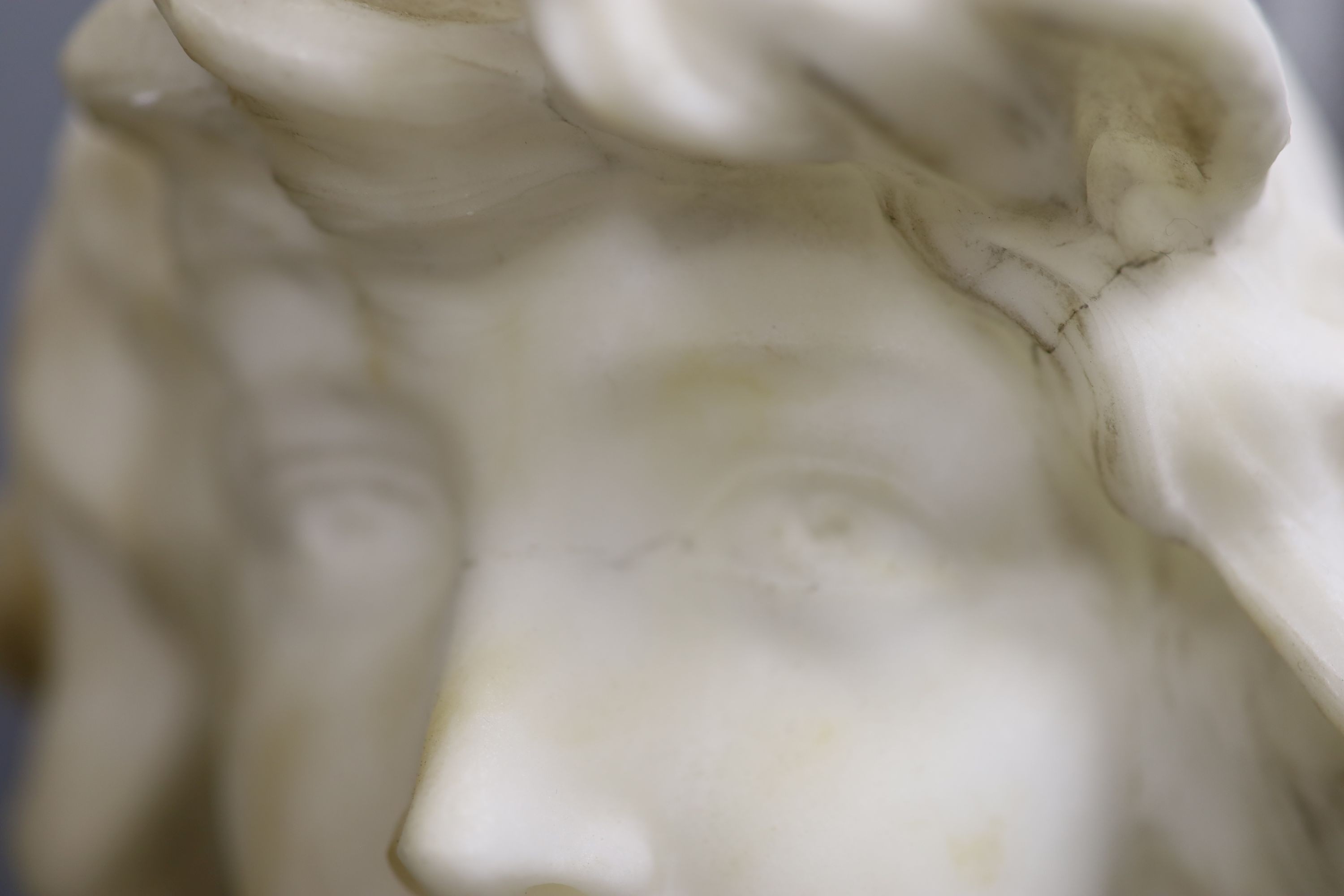 Two white alabaster busts of young women, raised on turned plinths 44cm